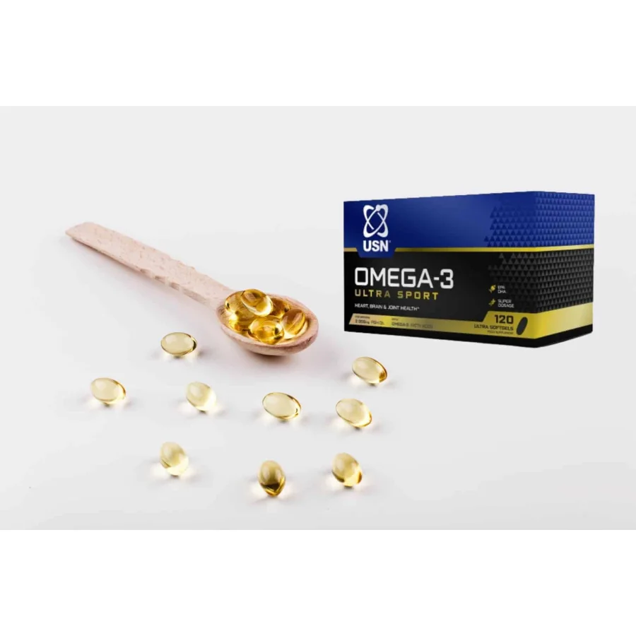 Oil capsule for hair with vitamin E lie on wooden spoon